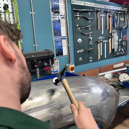 Action photo of panel beating tools being used